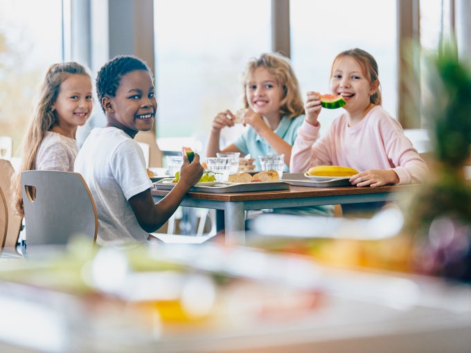 Kinder essen in einer Schulcafeteria, Symbolbild für die EU-Initiative zur Förderung gesunder Ernährung in Schulen und Kitas.